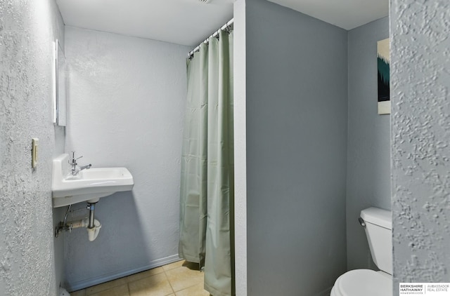 1409 S 17th St, Omaha, NE 68108 - bathroom featuring toilet, tile patterned floors, and a shower with curtain