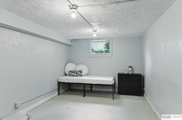 1409 S 17th St, Omaha, NE 68108 - bedroom featuring a textured ceiling, baseboards, concrete flooring, and a textured wall