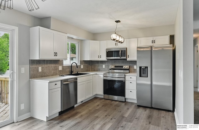 12956 Grand Ave, Omaha, NE 68164 - kitchen featuring stainless steel appliances, a sink, light wood-style floors, and tasteful backsplash