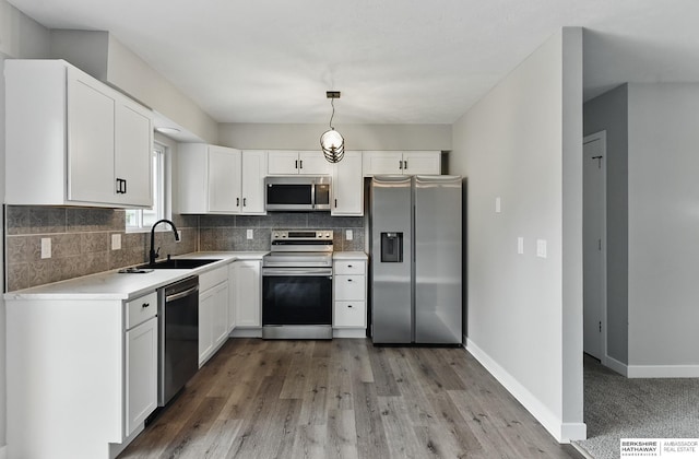 12956 Grand Ave, Omaha, NE 68164 - kitchen featuring appliances with stainless steel finishes, a sink, tasteful backsplash, and white cabinetry