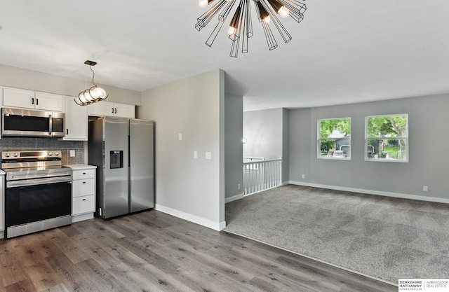 12956 Grand Ave, Omaha, NE 68164 - kitchen with appliances with stainless steel finishes, decorative backsplash, white cabinetry, dark wood-style flooring, and baseboards
