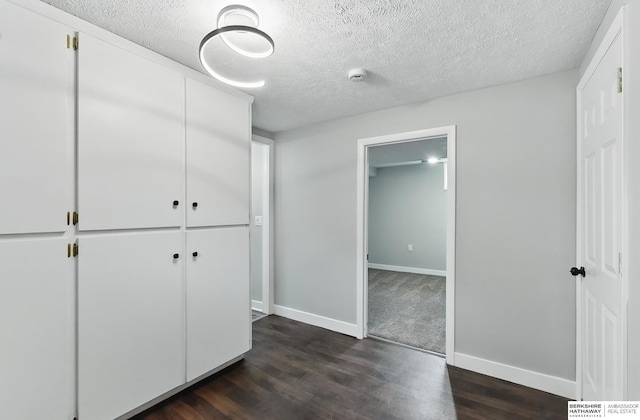 12956 Grand Ave, Omaha, NE 68164 - unfurnished bedroom featuring dark wood-type flooring, a textured ceiling, baseboards, and a closet