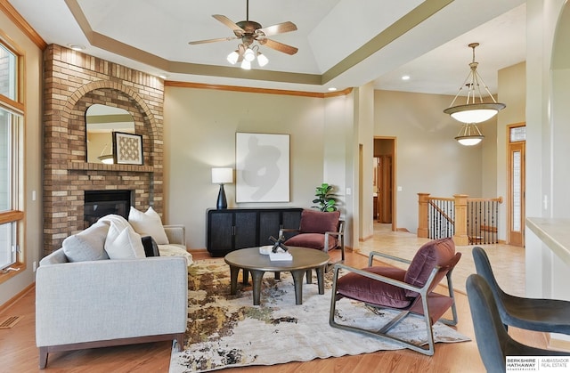 211 Longwood Dr, Papillion, NE 68133 - living room featuring wood finished floors, ceiling fan, a fireplace, a towering ceiling, and healthy amount of natural light