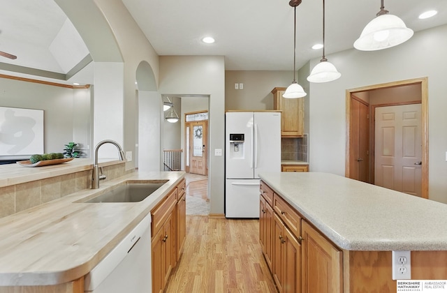211 Longwood Dr, Papillion, NE 68133 - kitchen featuring white appliances, a sink, arched walkways, a center island, and light countertops
