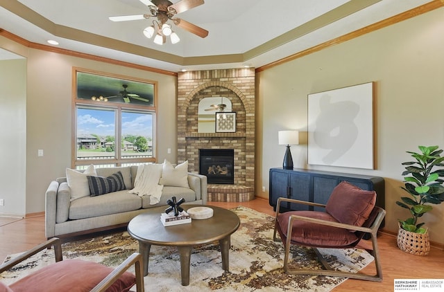211 Longwood Dr, Papillion, NE 68133 - living area featuring ceiling fan, baseboards, crown molding, a tray ceiling, and a brick fireplace