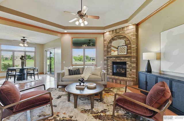 211 Longwood Dr, Papillion, NE 68133 - living room featuring a ceiling fan, healthy amount of natural light, a brick fireplace, and a tray ceiling