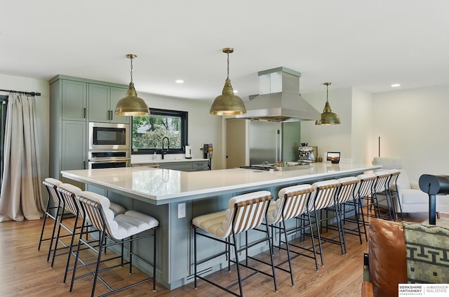 317 N 96th St, Omaha, NE 68114 - kitchen featuring stainless steel appliances, island exhaust hood, green cabinets, wood finished floors, and light countertops
