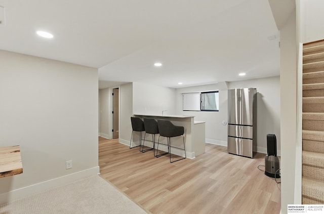 317 N 96th St, Omaha, NE 68114 - kitchen with freestanding refrigerator, recessed lighting, a kitchen bar, a peninsula, and light wood-style flooring