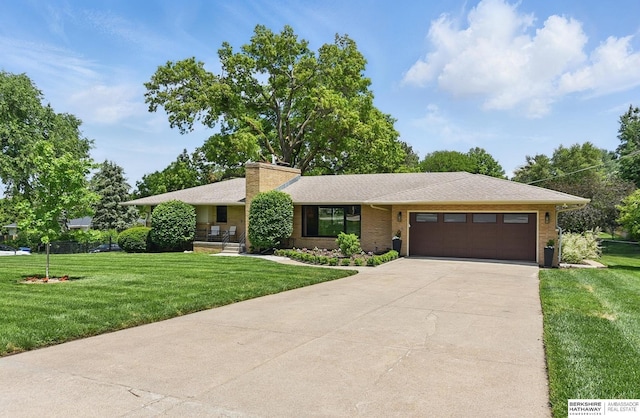 317 N 96th St, Omaha, NE 68114 - view of front of home with an attached garage, a front yard, concrete driveway, and a chimney