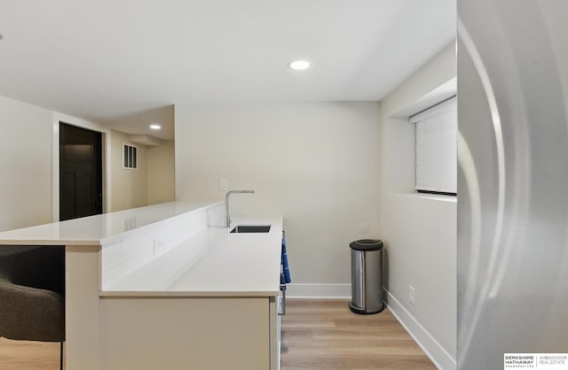 317 N 96th St, Omaha, NE 68114 - kitchen featuring freestanding refrigerator, a sink, light wood-type flooring, light countertops, and recessed lighting