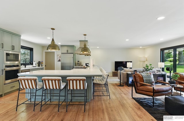 317 N 96th St, Omaha, NE 68114 - kitchen with appliances with stainless steel finishes, wall chimney exhaust hood, light countertops, open floor plan, and recessed lighting