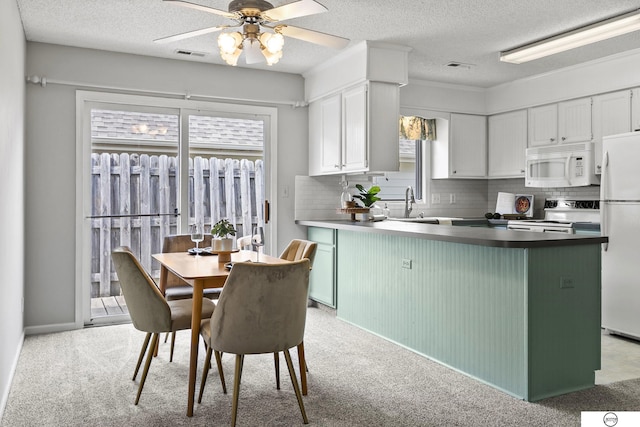 3400 Glenhaven Pl, Lincoln, NE 68506 - kitchen with white appliances, a textured ceiling, a peninsula, tasteful backsplash, and a ceiling fan