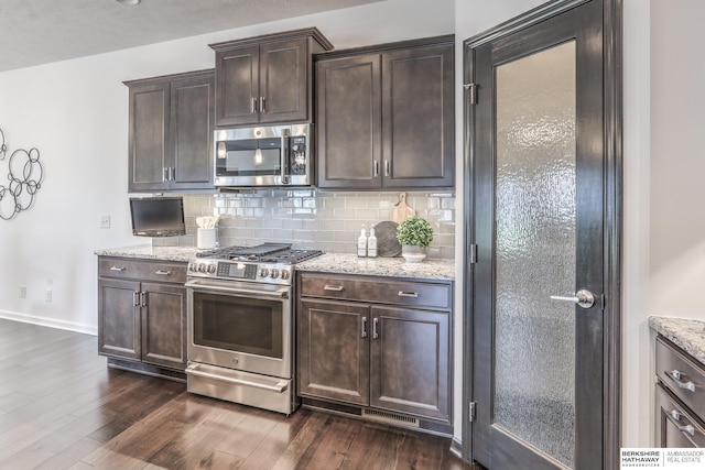 7812 S 196th St, Gretna, NE 68028 - kitchen featuring stainless steel appliances, tasteful backsplash, light stone countertops, dark wood finished floors, and dark brown cabinetry