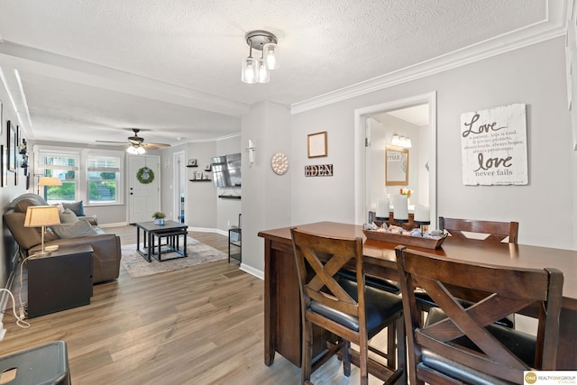 6458 Decatur St, Omaha, NE 68104 - dining space with light wood-style floors, a ceiling fan, crown molding, a textured ceiling, and baseboards