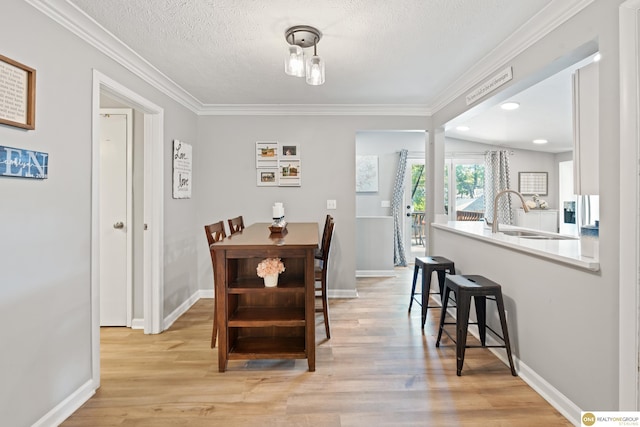 6458 Decatur St, Omaha, NE 68104 - dining area with light wood finished floors, ornamental molding, baseboards, and a textured ceiling