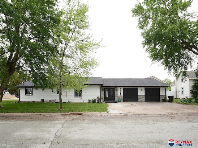 105 Nebraska St, Murdock, NE 68407 - ranch-style home featuring a garage, concrete driveway, a front lawn, and stone siding