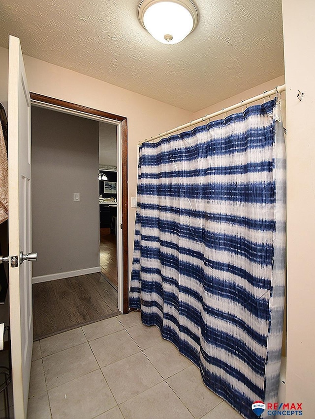 105 Nebraska St, Murdock, NE 68407 - full bath featuring tile patterned flooring, a textured ceiling, and a shower with shower curtain