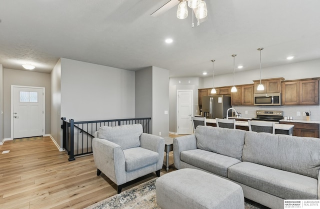 11745 S 113th St, Papillion, NE 68046 - living room with light wood finished floors, a ceiling fan, baseboards, and recessed lighting