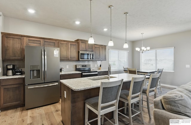 11745 S 113th St, Papillion, NE 68046 - kitchen with stainless steel appliances, a sink, decorative backsplash, light wood-style flooring, and recessed lighting