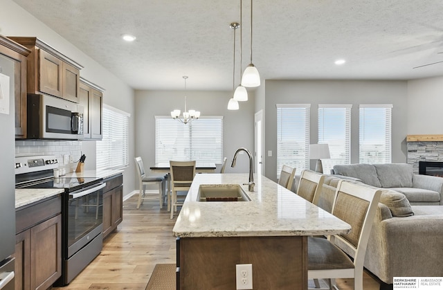 11745 S 113th St, Papillion, NE 68046 - kitchen with stainless steel appliances, a sink, a kitchen bar, tasteful backsplash, and a textured ceiling