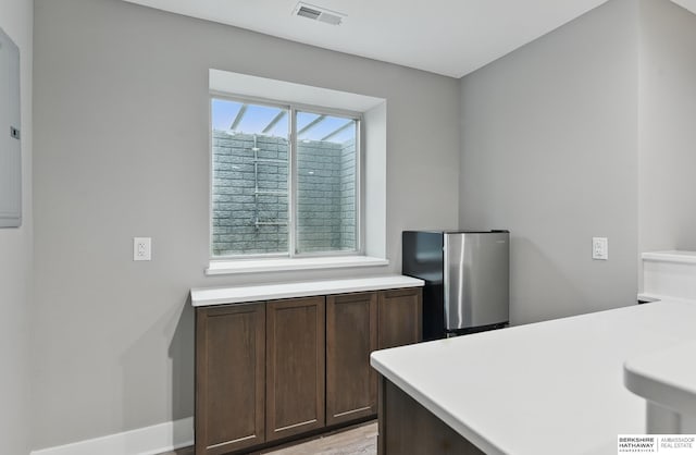 11745 S 113th St, Papillion, NE 68046 - kitchen with freestanding refrigerator, light countertops, dark brown cabinetry, and baseboards