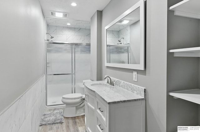11745 S 113th St, Papillion, NE 68046 - bathroom with a stall shower, toilet, wood finished floors, vanity, and recessed lighting