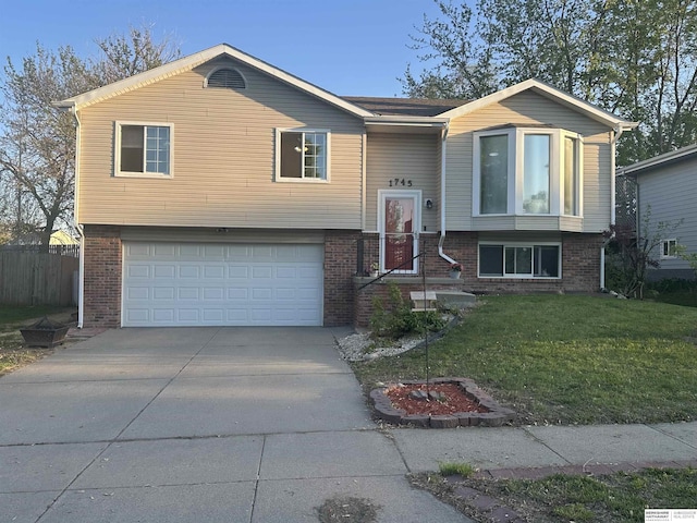 1745 Independence Cir, Lincoln, NE 68521 - split foyer home featuring a garage, brick siding, and driveway