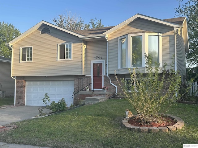 1745 Independence Cir, Lincoln, NE 68521 - split foyer home with an attached garage, a front yard, concrete driveway, and brick siding