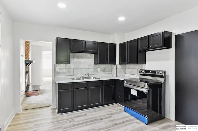 2544 N 64th St, Omaha, NE 68104 - kitchen with stainless steel range with electric cooktop, a sink, light wood-style flooring, backsplash, and light countertops