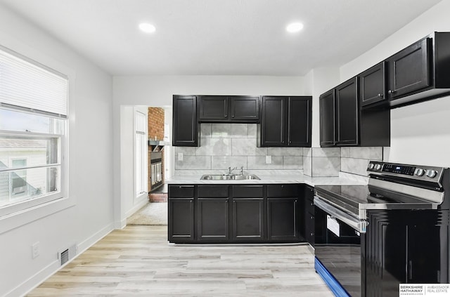 2544 N 64th St, Omaha, NE 68104 - kitchen with stainless steel electric stove, a sink, dark cabinets, recessed lighting, and tasteful backsplash