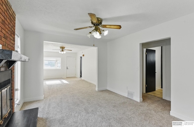 2544 N 64th St, Omaha, NE 68104 - unfurnished living room with a brick fireplace, carpet, ceiling fan, baseboards, and a textured ceiling