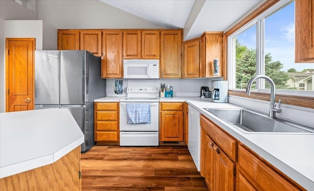 6718 Aspen St, La Vista, NE 68128 - kitchen with white appliances, a sink, wood finished floors, brown cabinets, and vaulted ceiling