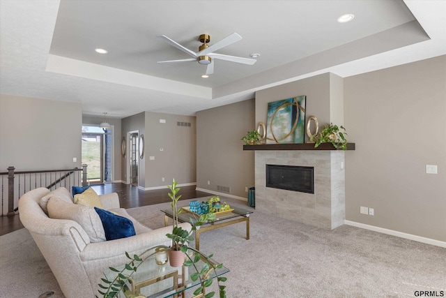 15301 Kansas Ave, Omaha, NE 68116 - living area with a tray ceiling, a ceiling fan, a fireplace, baseboards, and recessed lighting