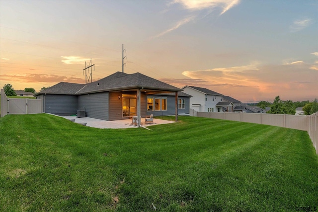 15301 Kansas Ave, Omaha, NE 68116 - back of house at dusk featuring a gate, a patio area, central air condition unit, and roof with shingles