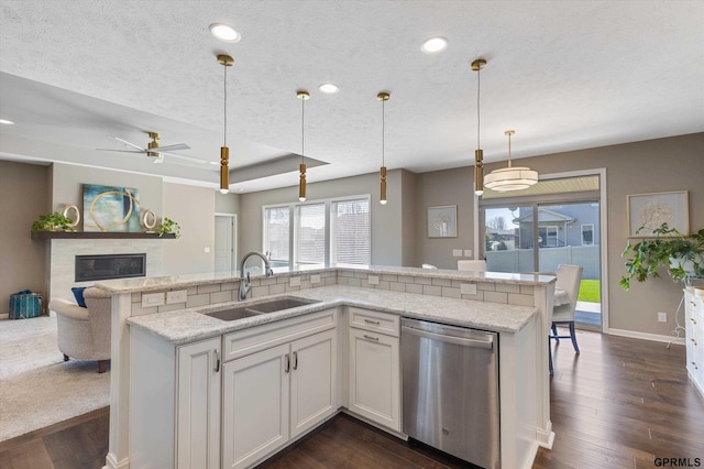 15301 Kansas Ave, Omaha, NE 68116 - kitchen featuring dishwasher, a sink, healthy amount of natural light, dark wood finished floors, and a textured ceiling