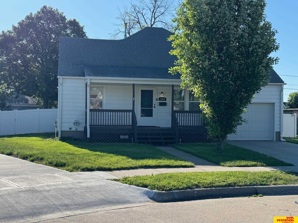 1461 E 2nd Ave, Fremont, NE 68025 - view of front of property with covered porch, an attached garage, a shingled roof, and concrete driveway