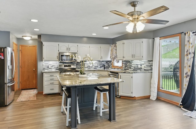 4414 S 174th St, Omaha, NE 68135 - kitchen with stainless steel appliances, light wood finished floors, white cabinetry, decorative backsplash, and recessed lighting