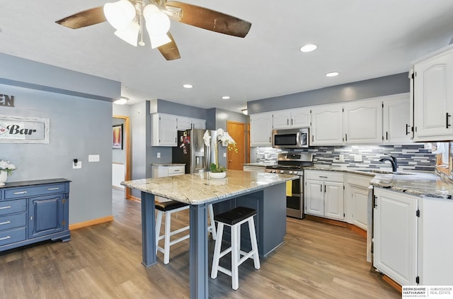 4414 S 174th St, Omaha, NE 68135 - kitchen featuring appliances with stainless steel finishes, light stone counters, a ceiling fan, wood finished floors, and recessed lighting