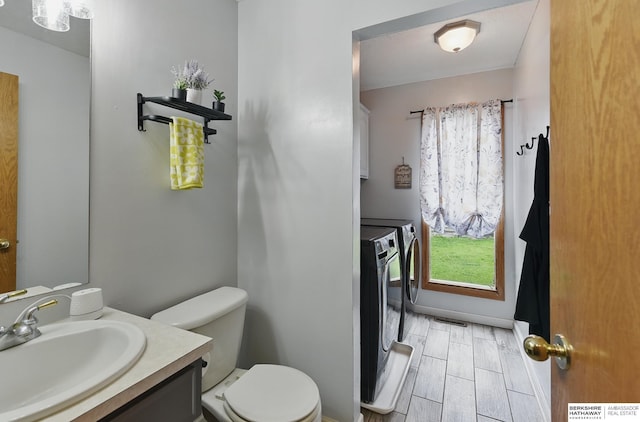 4414 S 174th St, Omaha, NE 68135 - bathroom with washing machine and clothes dryer, toilet, vanity, and plenty of natural light