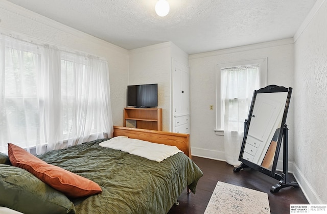 6920 N 30th St, Omaha, NE 68112 - bedroom featuring a textured wall, a textured ceiling, dark wood-type flooring, crown molding, and baseboards