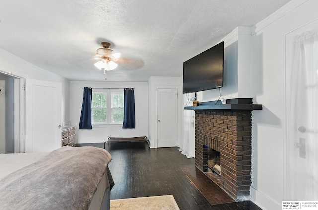 6920 N 30th St, Omaha, NE 68112 - bedroom with dark wood-style flooring, a fireplace, a textured ceiling, and a ceiling fan