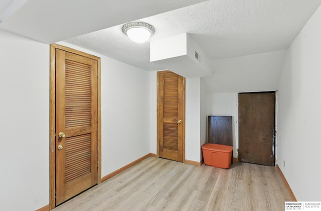 6920 N 30th St, Omaha, NE 68112 - unfurnished bedroom featuring light wood-style flooring, a closet, baseboards, and a textured ceiling