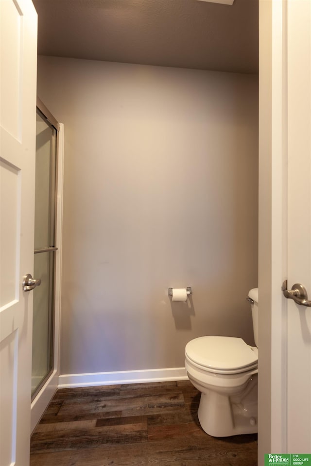 6311 N 169th St, Omaha, NE 68116 - bathroom with wood finished floors, toilet, a shower stall, and baseboards
