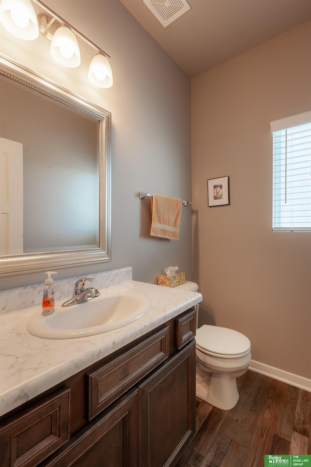 6311 N 169th St, Omaha, NE 68116 - half bath featuring wood finished floors, vanity, toilet, and baseboards