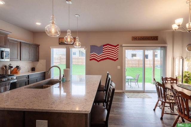 6311 N 169th St, Omaha, NE 68116 - kitchen featuring a sink, stainless steel microwave, dark wood-type flooring, decorative backsplash, and plenty of natural light