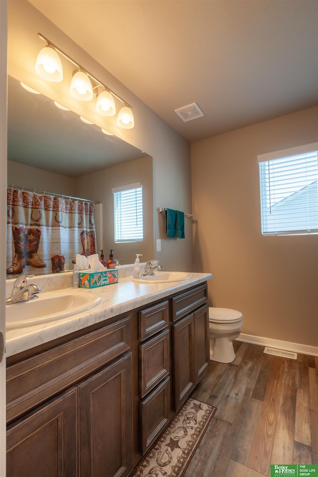 6311 N 169th St, Omaha, NE 68116 - bathroom featuring double vanity, toilet, wood finished floors, and baseboards