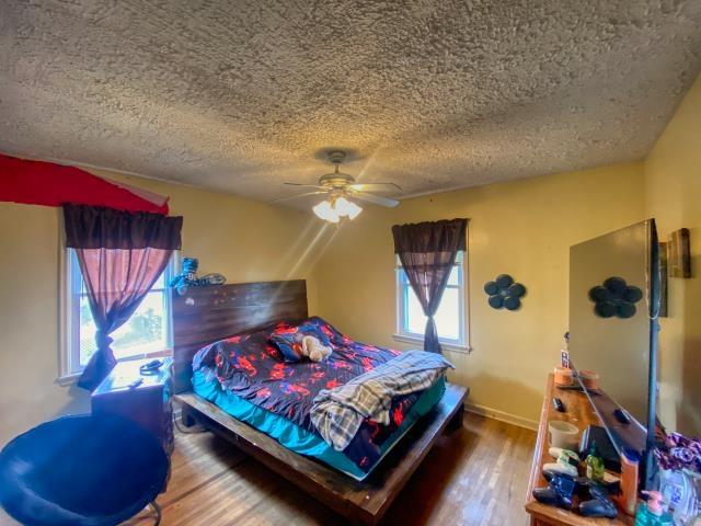4816 N 60th St, Omaha, NE 68104 - bedroom with a textured ceiling, wood finished floors, and a ceiling fan