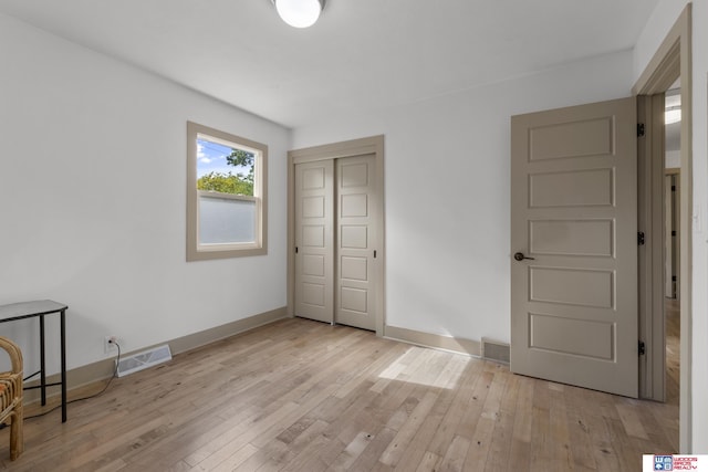 1141 S 48th St, Lincoln, NE 68510 - unfurnished bedroom with light wood-style floors, a closet, and baseboards