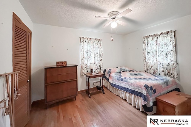6251 Nebraska Ave, Omaha, NE 68104 - bedroom with light wood-style floors, baseboards, a closet, a textured ceiling, and ceiling fan