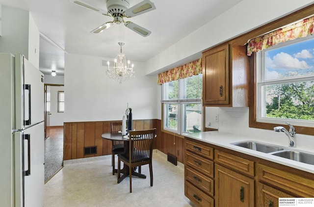 4314 Oak St, Omaha, NE 68105 - kitchen with freestanding refrigerator, a sink, brown cabinetry, light countertops, and ceiling fan